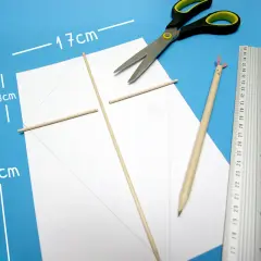 Jak zrobić latawiec z papieru: biały papier, patyczki, nożyczki, linijka i ołówek czekają na kreatywne ręce.