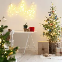 Choinka, prezenty i lampki świąteczne w przytulnym wnętrzu.