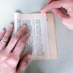 Składanie kartki z książki, by stworzyć torebkę na prezent. Prosty sposób, jak zrobić torebkę na prezent z papieru.
