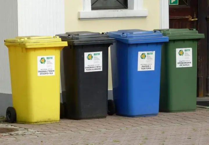 Cztery kolorowe kosze na śmieci: żółty (tworzywa sztuczne), czarny (metale), niebieski (papier) i zielony (szkło). Gdzie wyrzucić opakowanie po galaretce? Do żółtego kosza, jeśli jest plastikowe.
