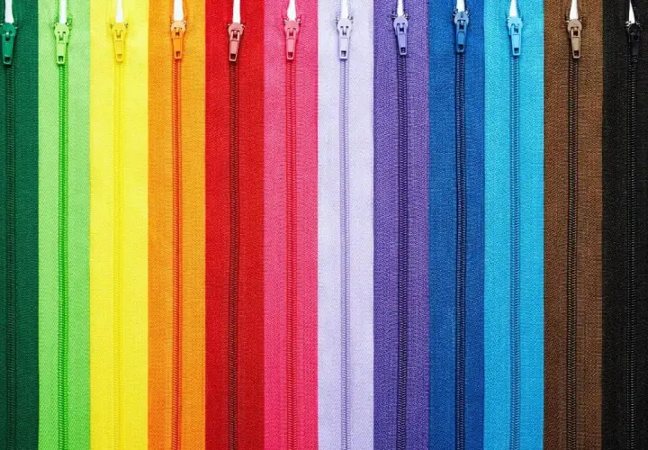 Kolorowe zamki błyskawiczne ułożone pionowo, idealne do nauki jak wszyć zamek kryty.