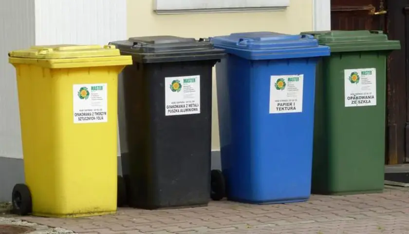 Cztery kolorowe kosze na śmieci: żółty (tworzywa sztuczne), czarny (metale), niebieski (papier) i zielony (szkło). Gdzie wyrzucić opakowanie po galaretce? Do żółtego kosza, jeśli jest plastikowe.