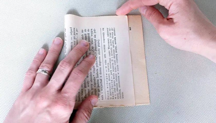 Składanie kartki z książki, by stworzyć torebkę na prezent. Prosty sposób, jak zrobić torebkę na prezent z papieru.