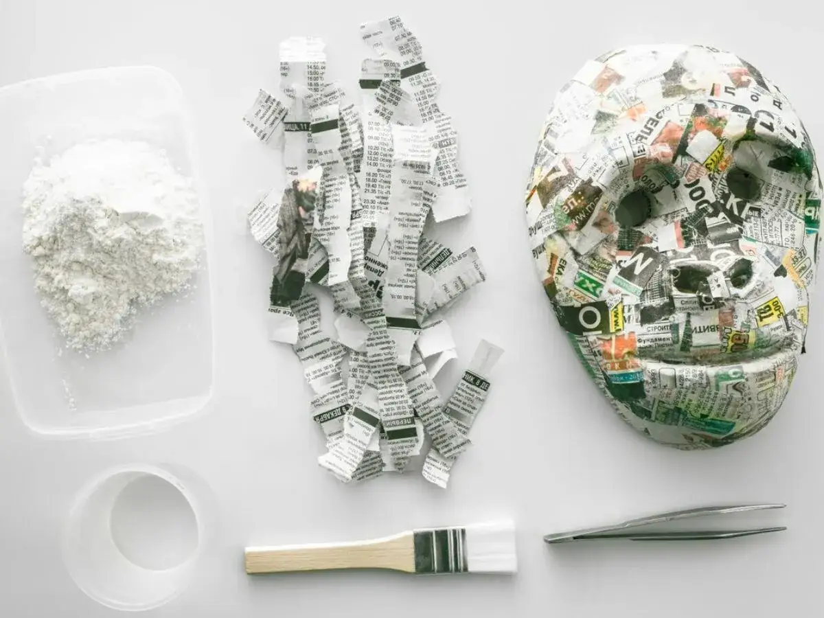 Materiały do zrobienia kuli z papieru i kleju: papier, klej, pędzel, pęseta i maska.